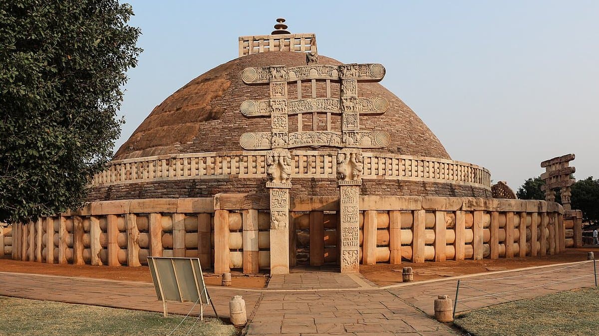 Rounded Great Stupa at Sanchi seen with one of its intricately carved stone gateways.
