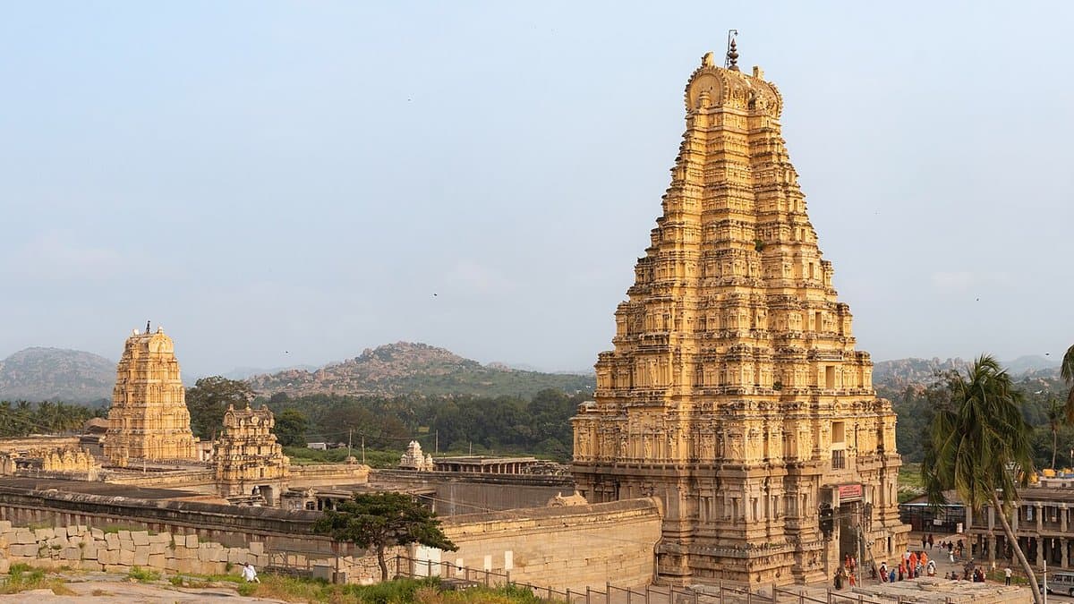 Virupaksha temple and gateway tower amid the rocky landscape of Hampi.