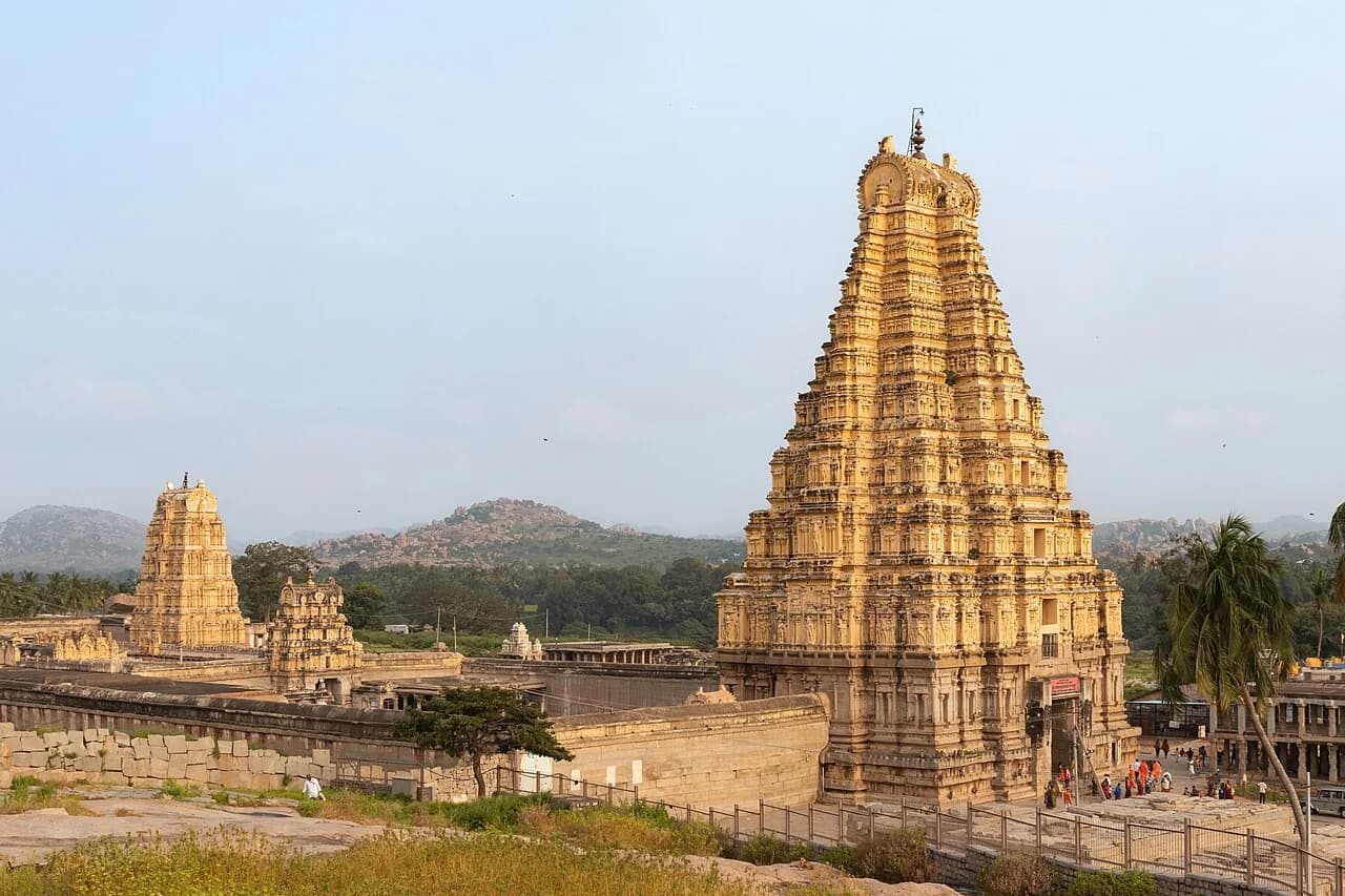 Virupaksha temple and gateway tower amid the rocky landscape of Hampi.