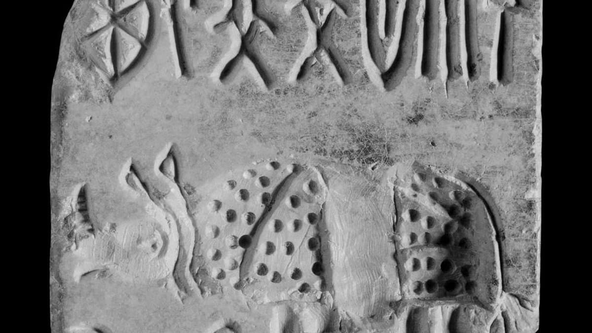 Square stone seal with a rhinoceros below a short line of Indus signs.