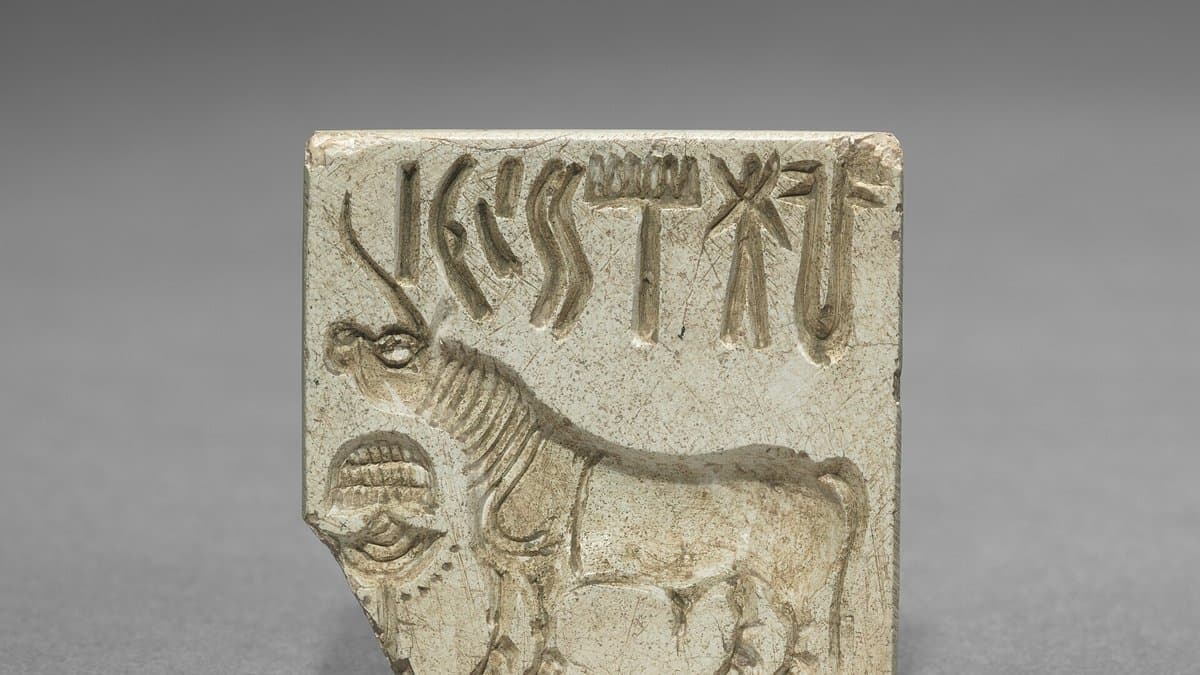 Small square carved seal with a row of signs above a one-horned animal.