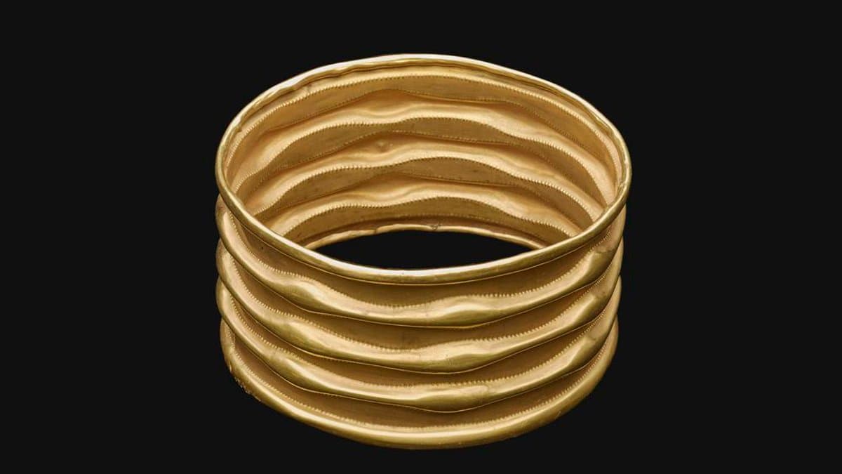 Ribbed sheet-gold armlet from Lockington photographed against a dark background.