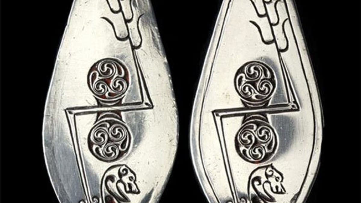 Two similar leaf-shaped silver plaques with Pictish symbols displayed side by side.