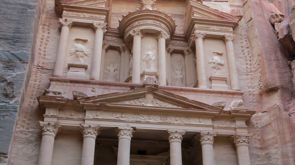 Rock-cut two-level façade of Al-Khazneh framed by Petra’s sandstone cliffs.