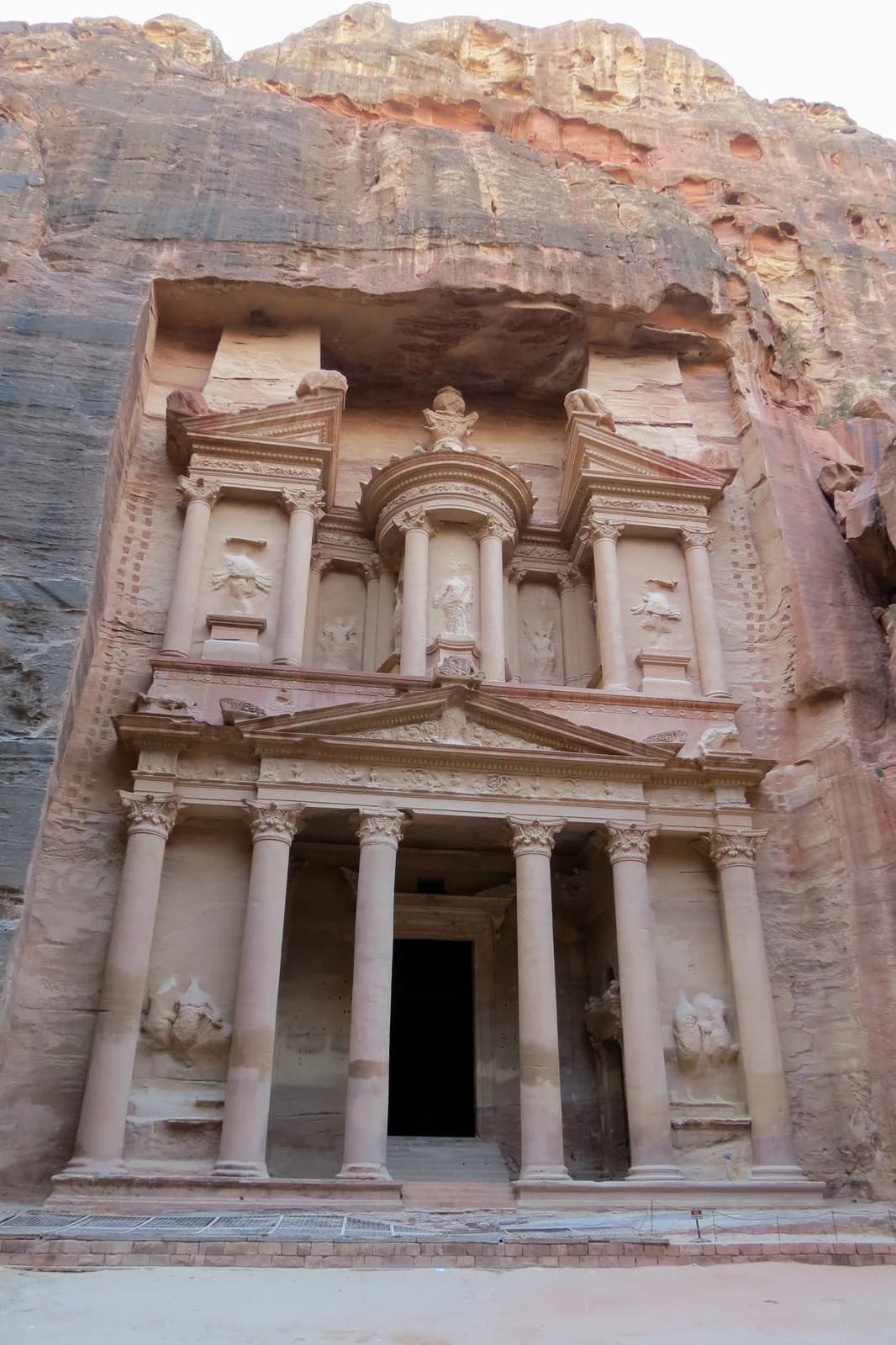 Rock-cut two-level façade of Al-Khazneh framed by Petra’s sandstone cliffs.