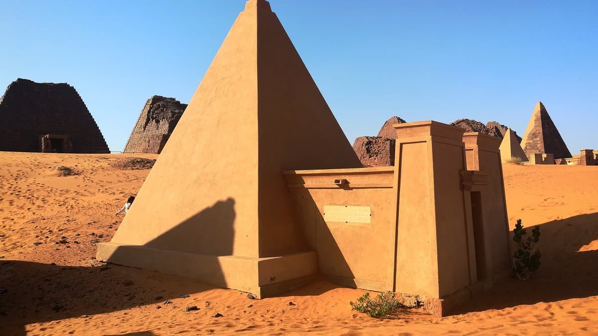 Cluster of steep-sided Kushite pyramids in the semi-desert landscape of Meroe.