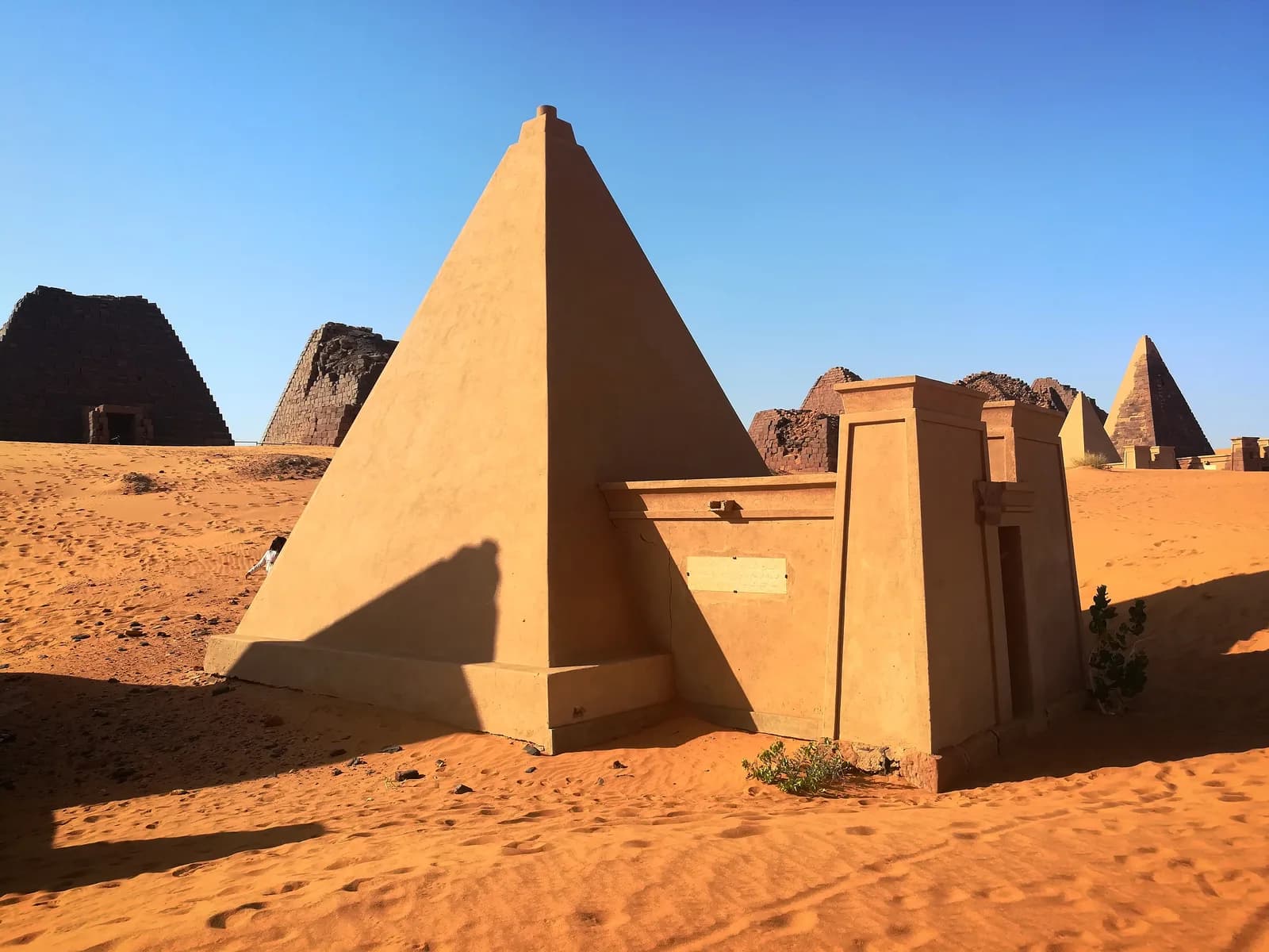 Cluster of steep-sided Kushite pyramids in the semi-desert landscape of Meroe.
