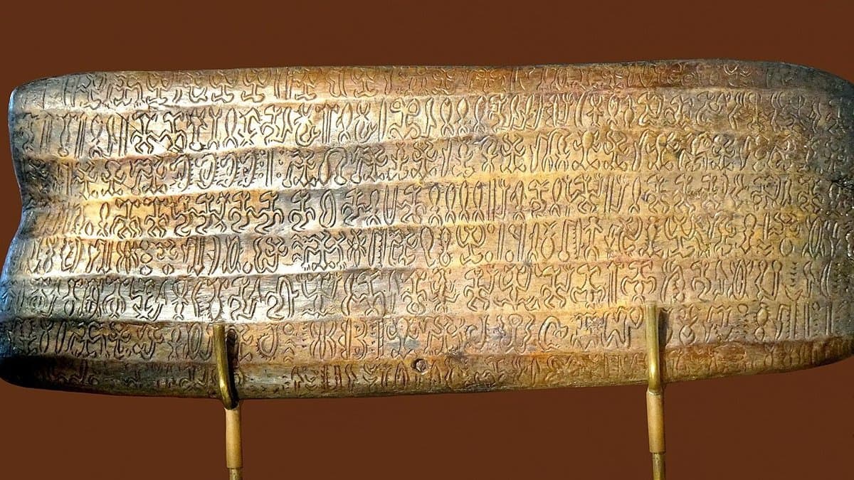 Carved signs in rows on a modern wooden reproduction of a rongorongo tablet.