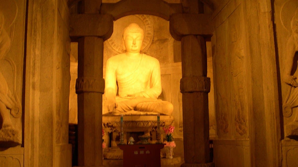 Seated stone Buddha seen through the inner chamber of Seokguram Grotto.
