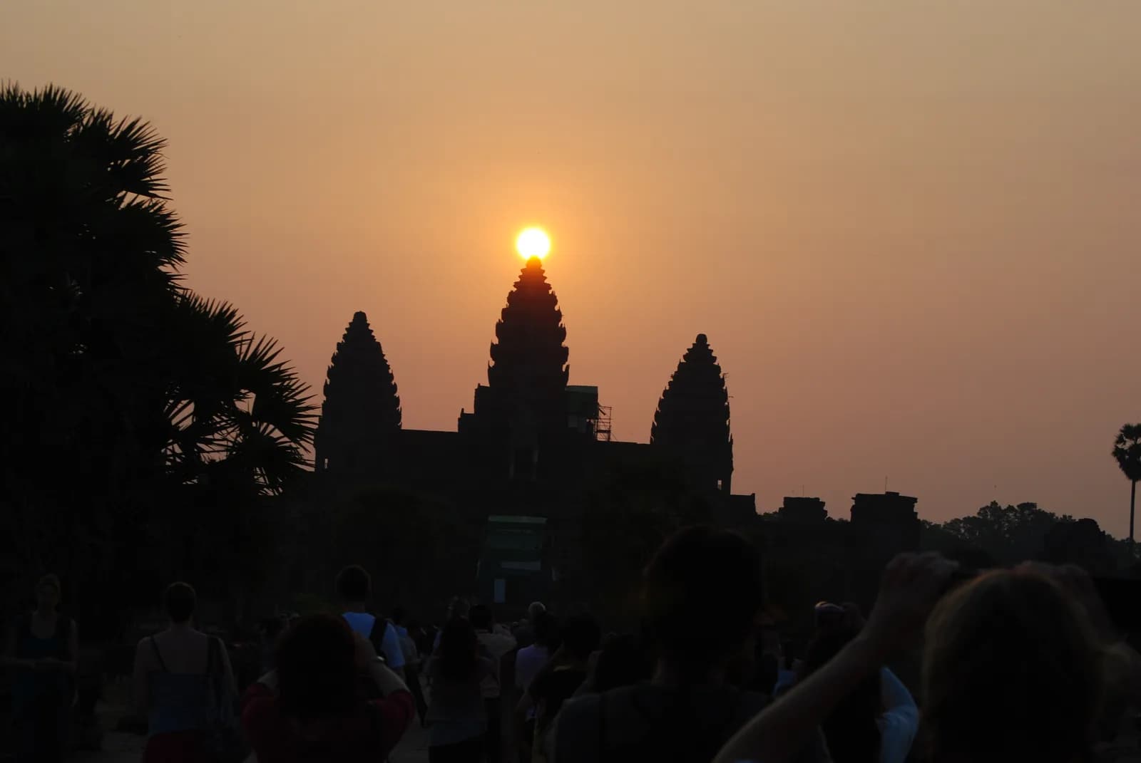 Angkor Wat towers reflected in water with the temple complex beyond.