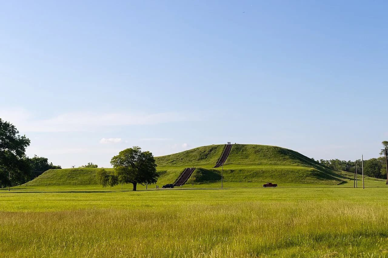 Large grass-covered stepped Monks Mound rising above the Cahokia landscape.