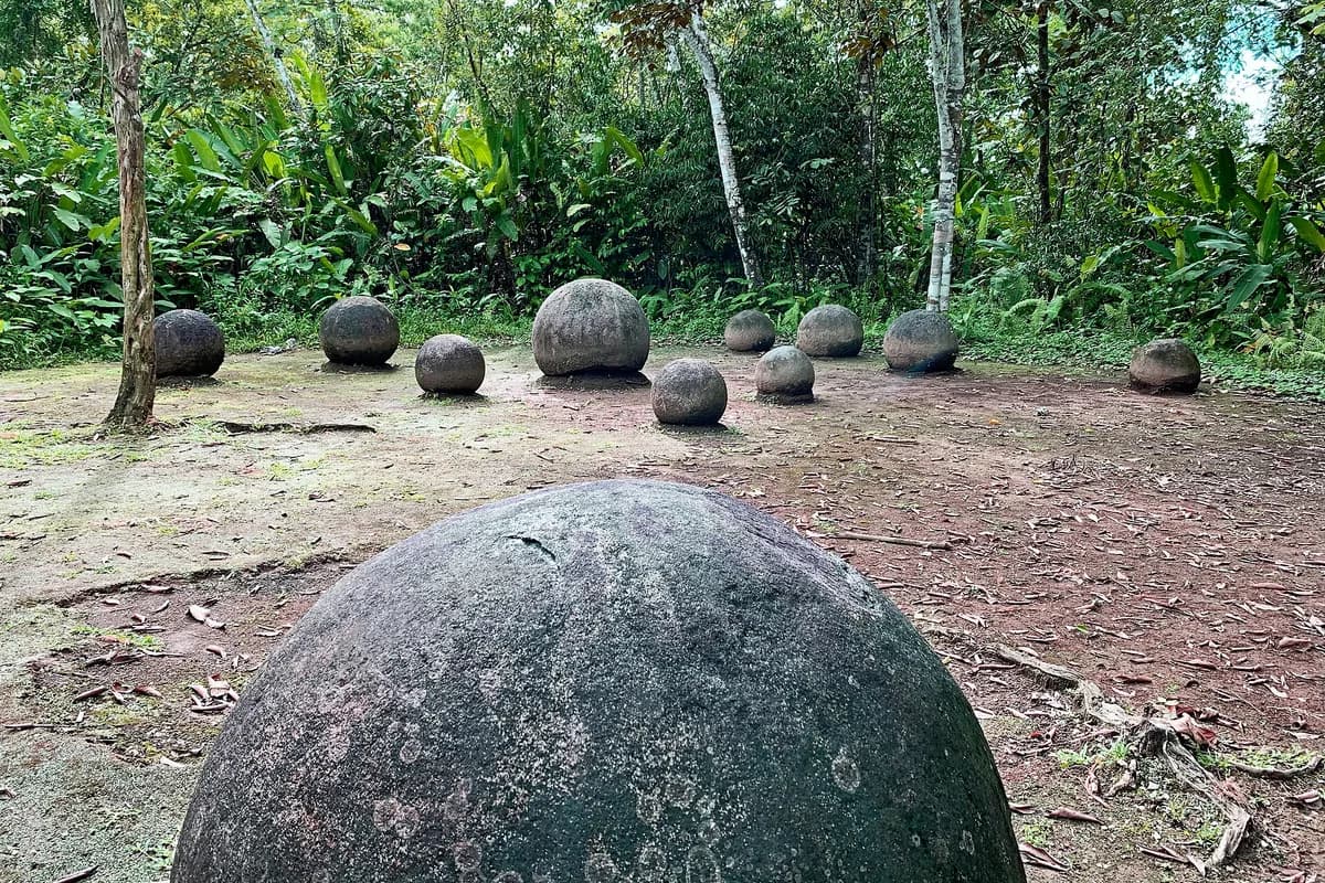 Large stone spheres in a grassy archaeological setting.